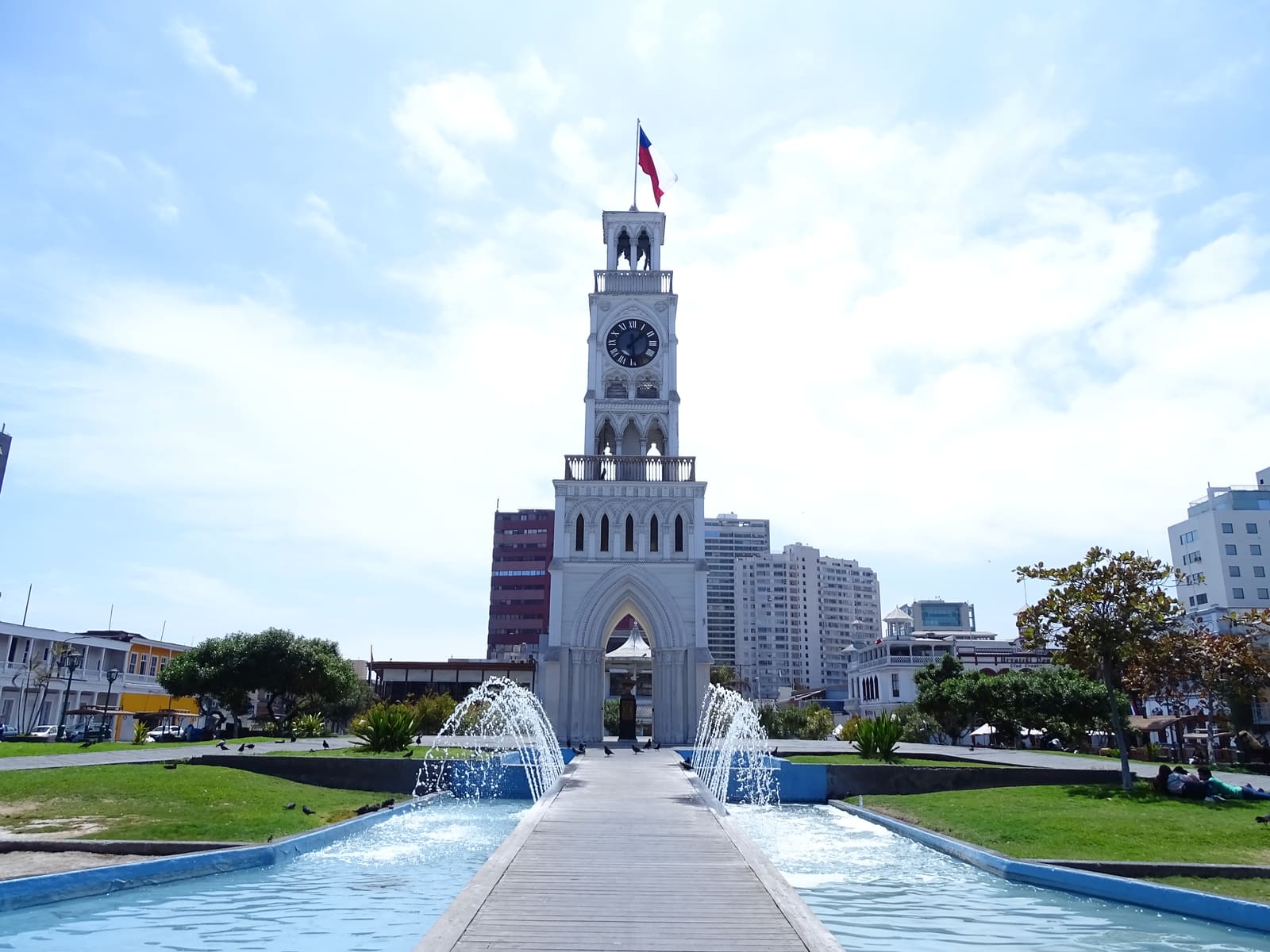 Banca y palmeras de la plaza con la torre de fondo