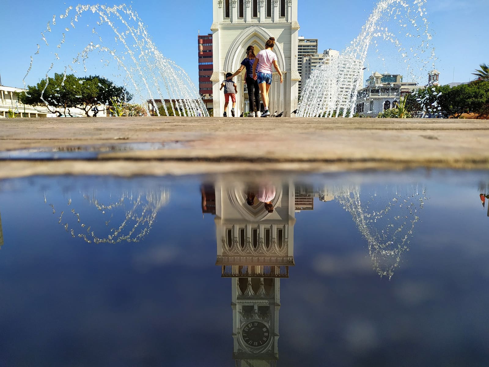 Atardecer cálido sobre la plaza y la torre iluminada